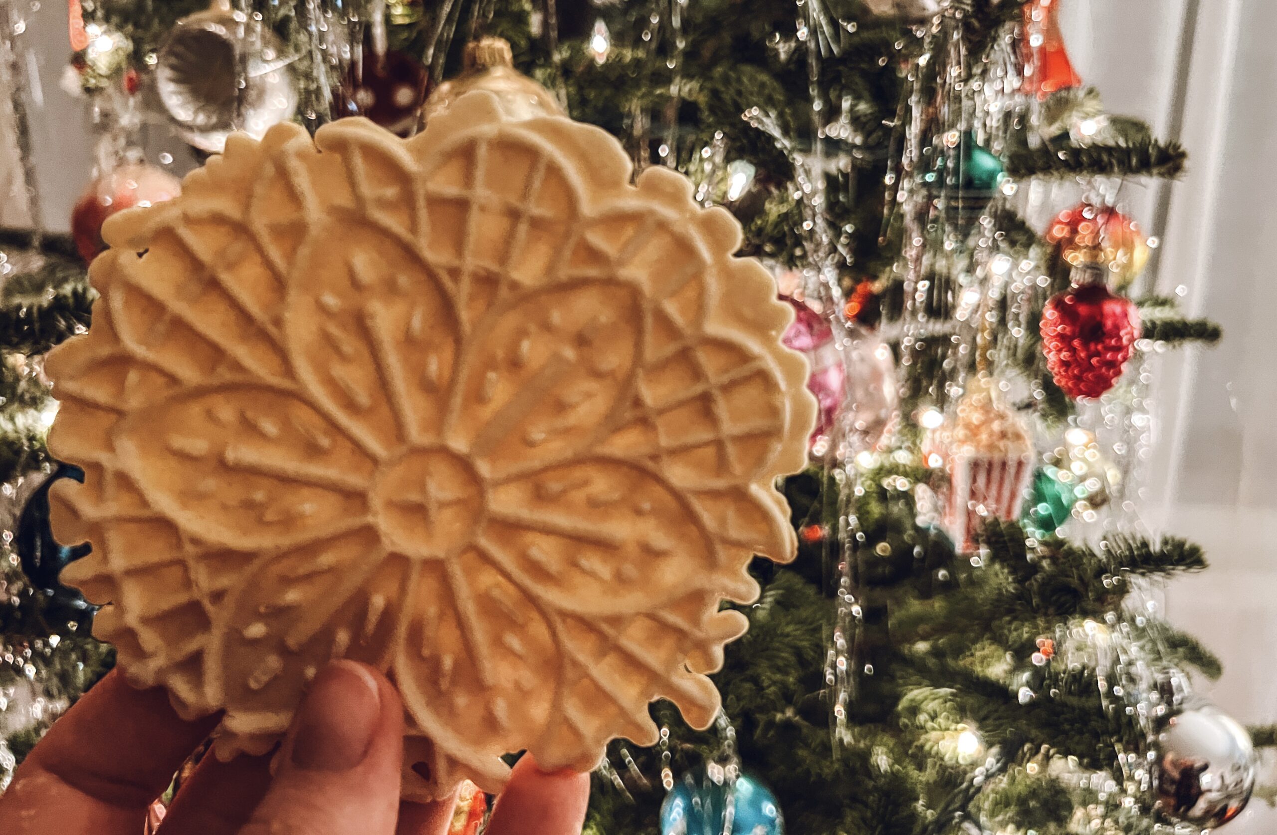 Pizzelle cookie in front of Christmas tree